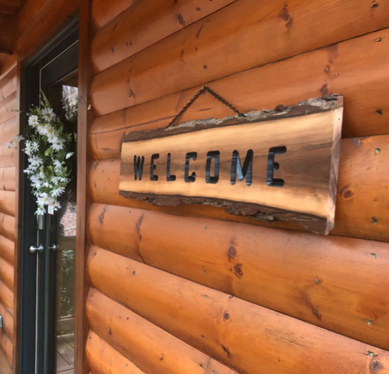 Welcome sign made out of rustic live edge wood.